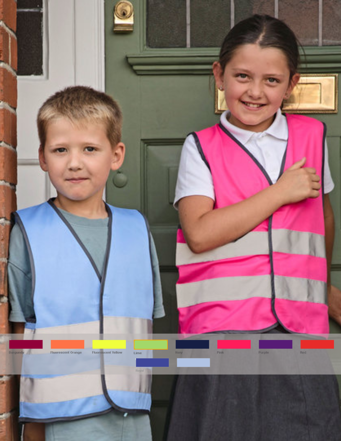 Twee kinderen in gestreepte schorten, staand voor een groene deur, glimlachend en poseren.